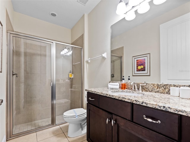 bathroom with vanity, a shower with shower door, tile patterned floors, and toilet