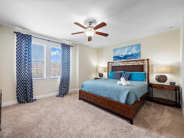 carpeted bedroom with ceiling fan and a textured ceiling