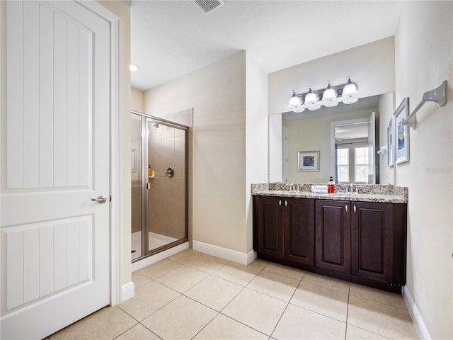 bathroom featuring walk in shower, tile patterned floors, vanity, and a textured ceiling