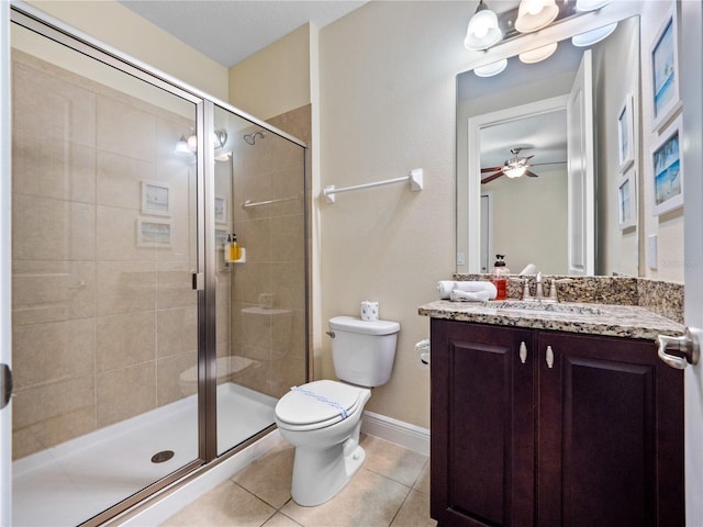 bathroom featuring vanity, a shower with shower door, tile patterned floors, and toilet