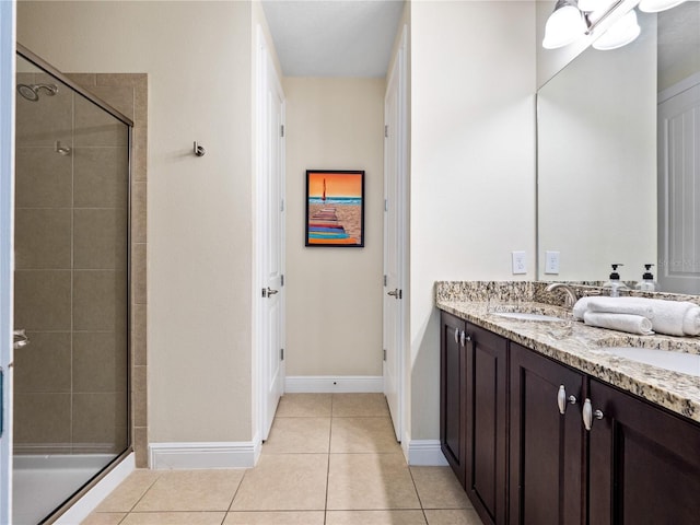 bathroom with tile patterned floors, a shower with door, and vanity