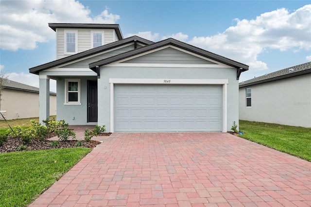 view of front facade with a garage, a front lawn, decorative driveway, and stucco siding