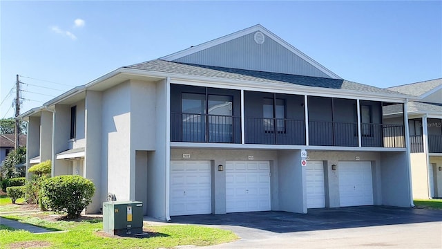 4448 Pinebark Ave Unit 56-1, Orlando, FL 32811 - rear view of property featuring stucco siding, a shingled roof, driveway, and an attached garage