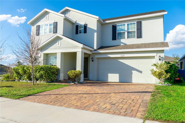 view of property with a garage and a front lawn