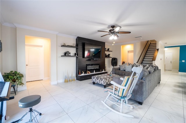 living room with ornamental molding, a large fireplace, and ceiling fan