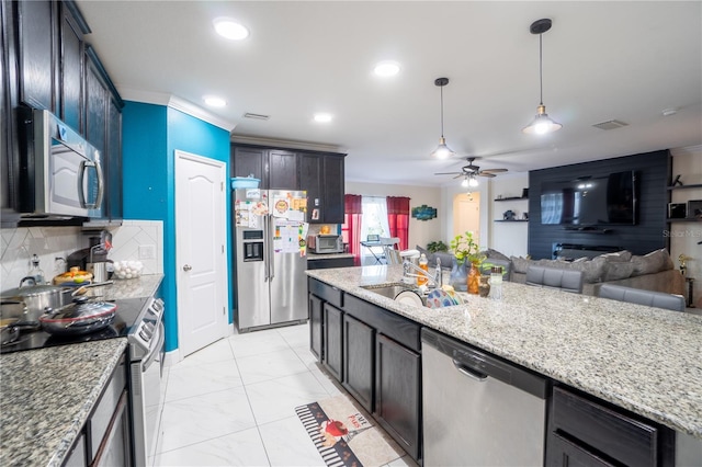 kitchen with sink, crown molding, backsplash, dark brown cabinets, and stainless steel appliances