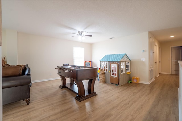 rec room with ceiling fan and light hardwood / wood-style flooring