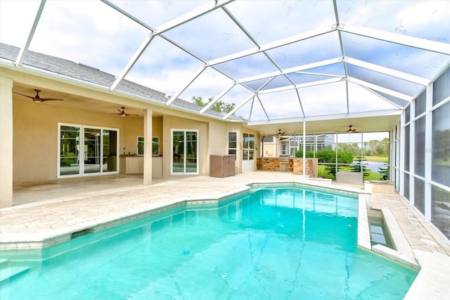 view of swimming pool featuring ceiling fan, area for grilling, a patio area, and glass enclosure