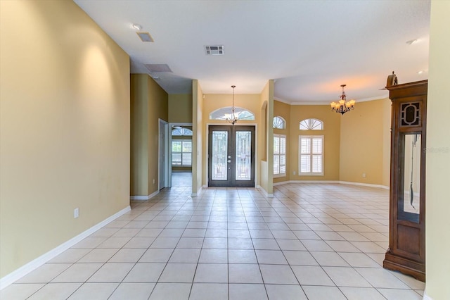 entrance foyer featuring french doors, a healthy amount of sunlight, light tile patterned floors, and a notable chandelier