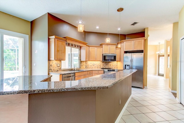 kitchen featuring light tile patterned flooring, appliances with stainless steel finishes, backsplash, hanging light fixtures, and light brown cabinets