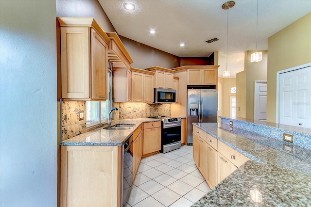 kitchen featuring light brown cabinetry, sink, hanging light fixtures, appliances with stainless steel finishes, and light stone countertops