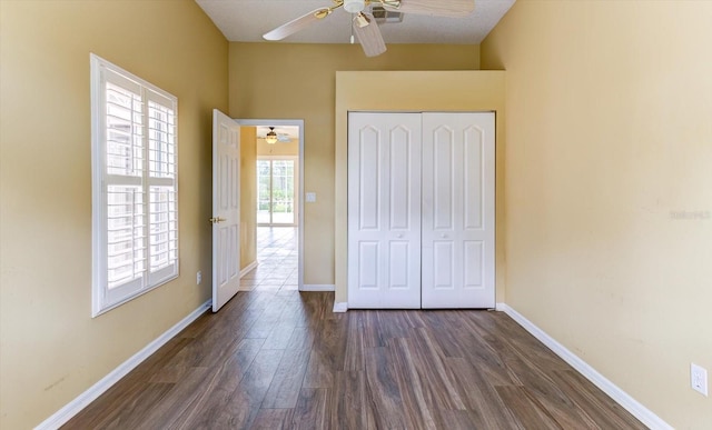 unfurnished bedroom with dark wood-type flooring, ceiling fan, and a closet