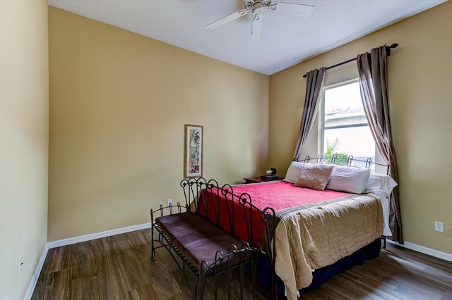 bedroom with ceiling fan, dark hardwood / wood-style floors, and a textured ceiling