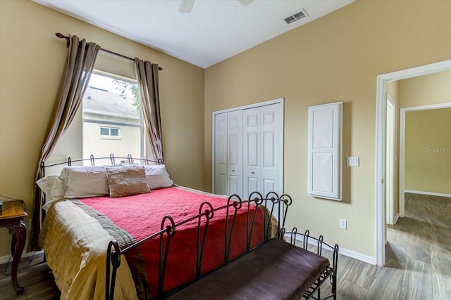 bedroom featuring hardwood / wood-style floors, a textured ceiling, a closet, and ceiling fan