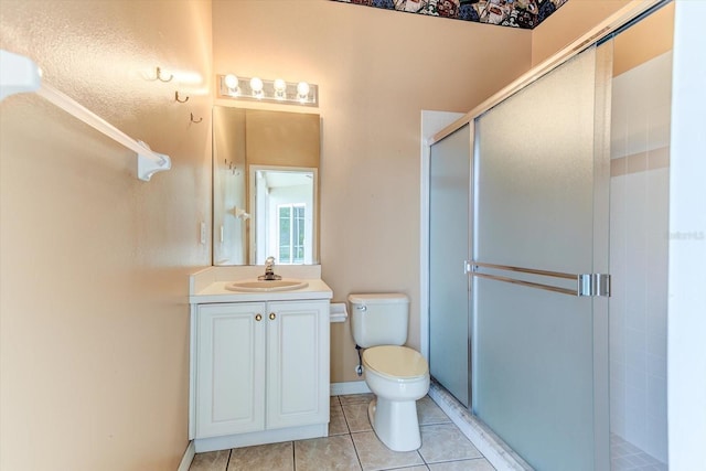 bathroom with walk in shower, vanity, toilet, and tile patterned flooring