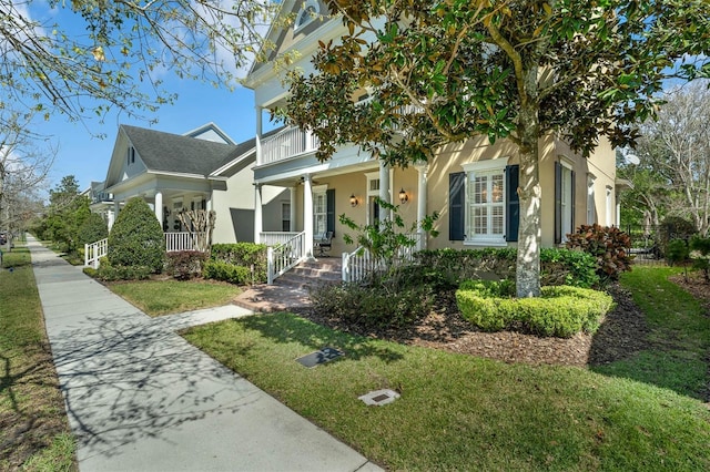 view of front facade featuring a front lawn, a porch, and stucco siding