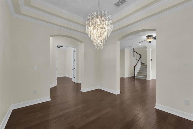 spare room with arched walkways, dark wood-type flooring, visible vents, stairs, and a raised ceiling