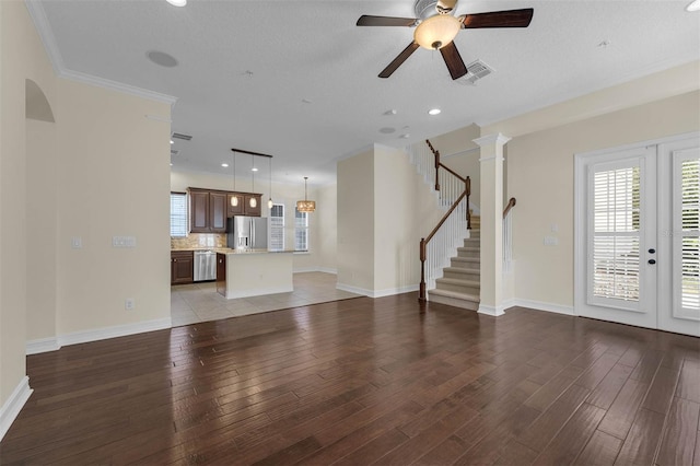 unfurnished living room featuring a wealth of natural light, stairway, light wood-style flooring, and baseboards