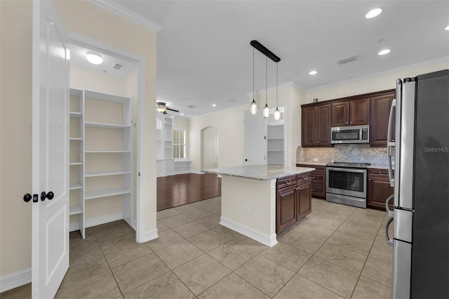 kitchen featuring arched walkways, stainless steel appliances, tasteful backsplash, visible vents, and ornamental molding