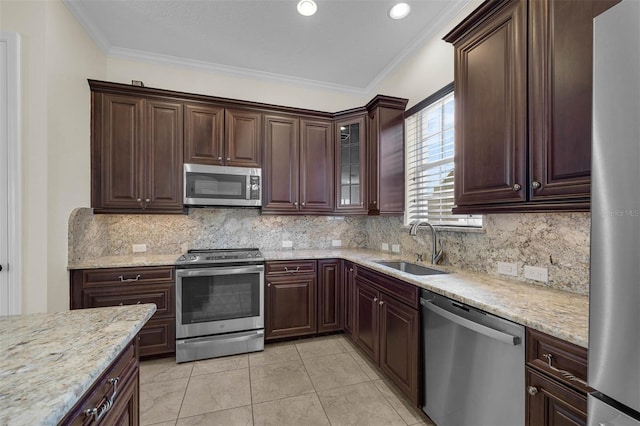 kitchen with light stone counters, stainless steel appliances, tasteful backsplash, ornamental molding, and a sink