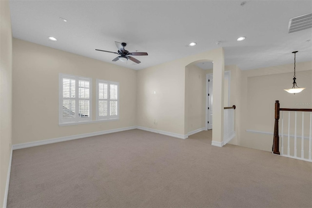 empty room featuring arched walkways, recessed lighting, visible vents, light carpet, and baseboards