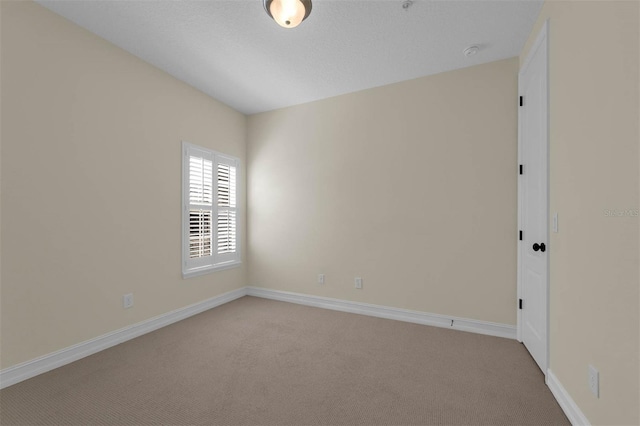 carpeted empty room featuring baseboards