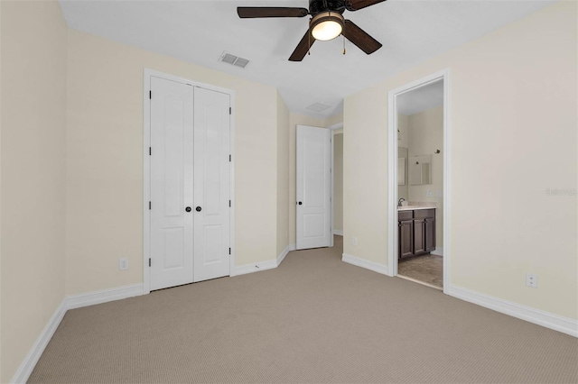 unfurnished bedroom with light colored carpet, a closet, visible vents, and baseboards