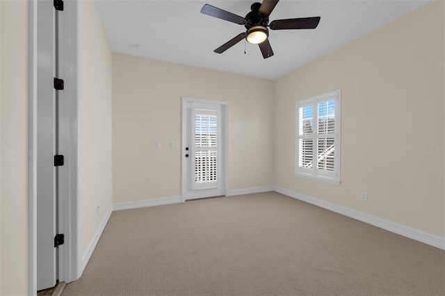 unfurnished room with light carpet, a ceiling fan, and baseboards