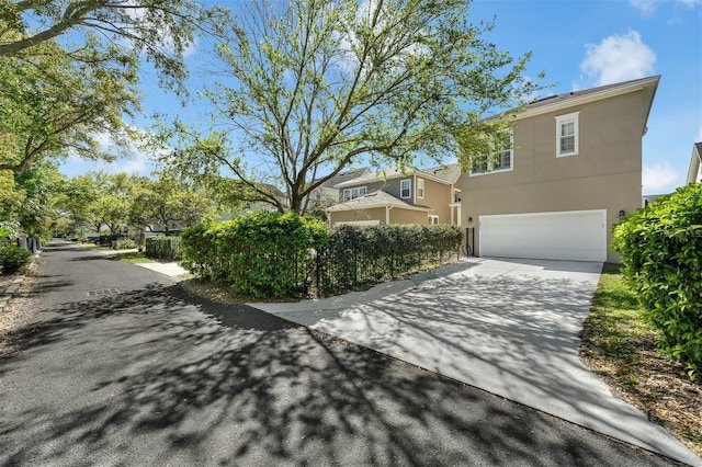 exterior space with a garage, driveway, and stucco siding