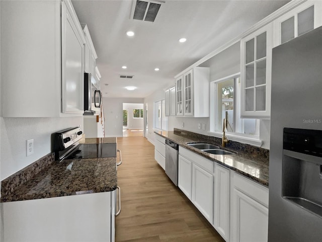 662 Lake Dr, Altamonte Springs, FL 32701 - kitchen with white cabinetry, appliances with stainless steel finishes, and glass insert cabinets