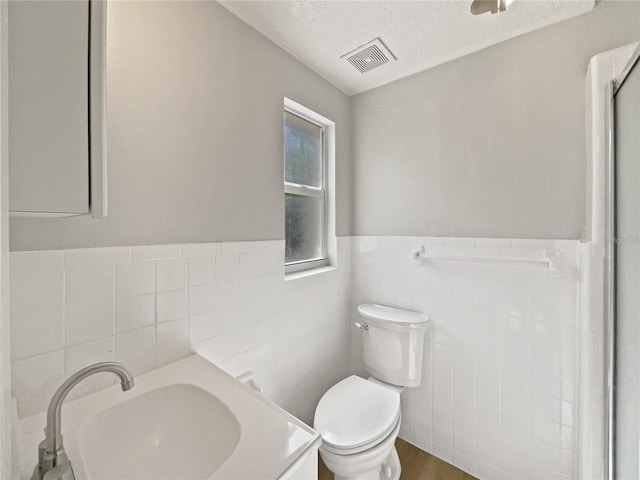662 Lake Dr, Altamonte Springs, FL 32701 - bathroom with a wainscoted wall, visible vents, toilet, a textured ceiling, and vanity