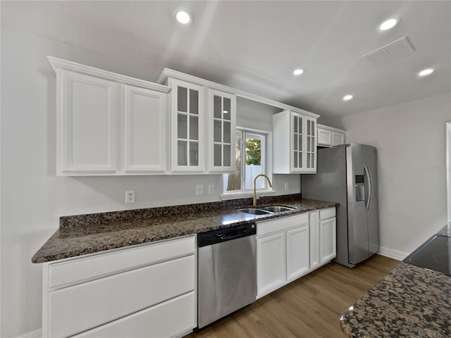 662 Lake Dr, Altamonte Springs, FL 32701 - kitchen with glass insert cabinets, appliances with stainless steel finishes, dark stone countertops, white cabinetry, and a sink