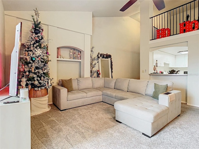 living room with carpet floors, vaulted ceiling, and ceiling fan