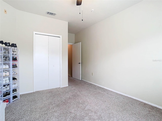 unfurnished bedroom with carpet floors, ceiling fan, and a closet