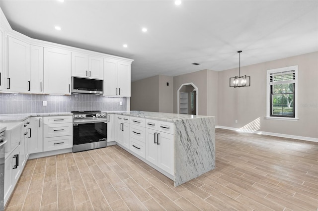 kitchen featuring white cabinets, stainless steel appliances, and decorative backsplash