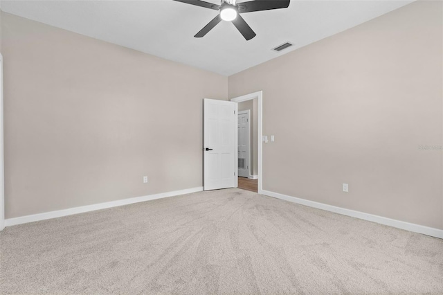 unfurnished room with light colored carpet, ceiling fan, visible vents, and baseboards
