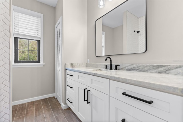 full bath featuring wood tiled floor, a closet, vanity, and baseboards