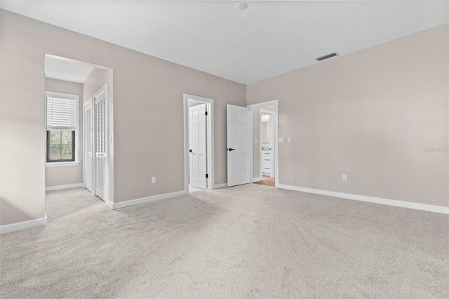interior space with light carpet, visible vents, and baseboards