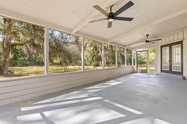unfurnished sunroom featuring lofted ceiling with beams and french doors
