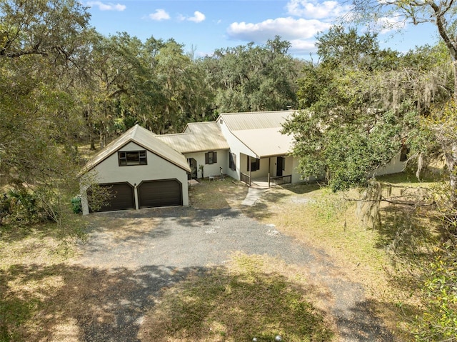 view of front of house with gravel driveway and metal roof