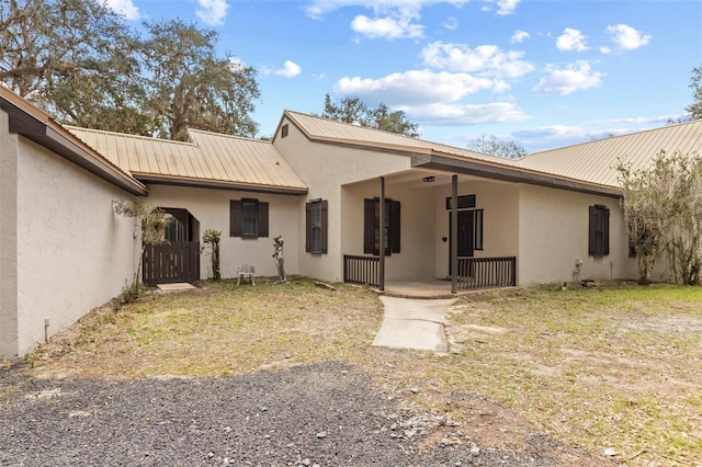 exterior space with metal roof and stucco siding
