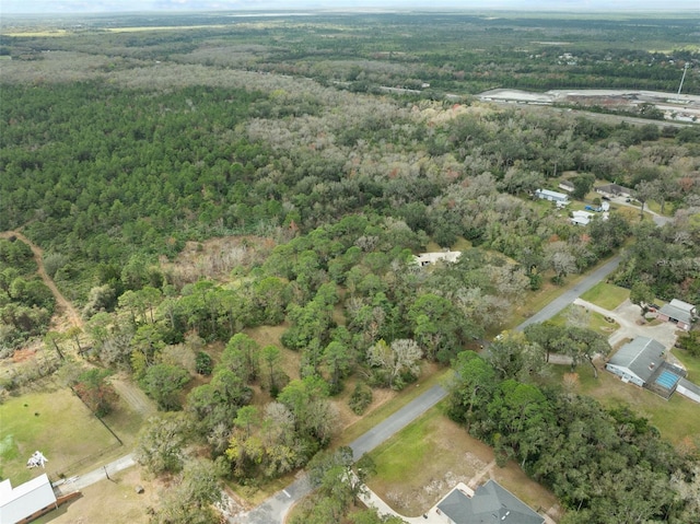 bird's eye view with a wooded view