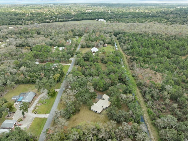 drone / aerial view featuring a wooded view