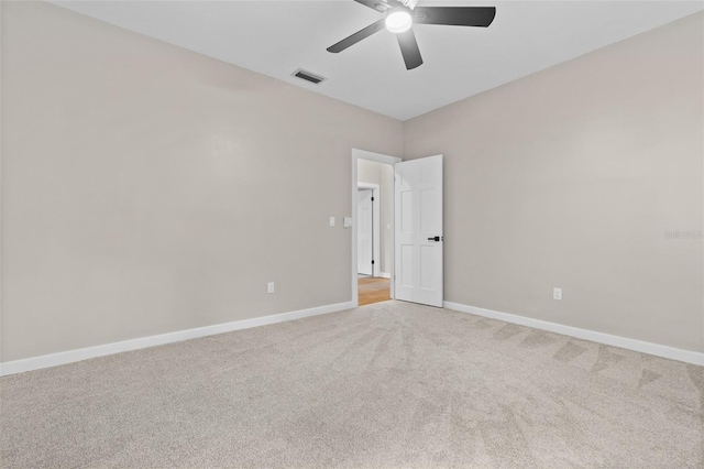 carpeted spare room with baseboards, visible vents, and ceiling fan