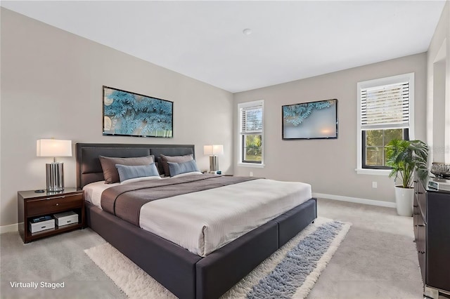 bedroom with light carpet, multiple windows, and baseboards