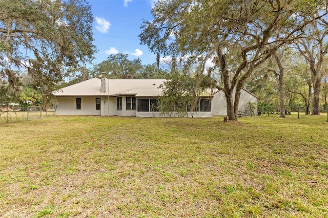 back of house featuring a yard and fence