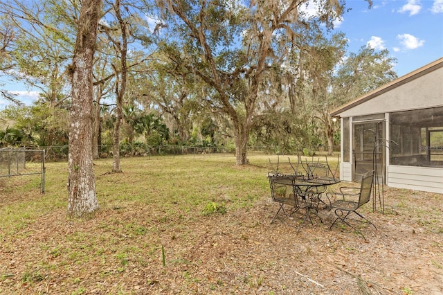 view of yard with a sunroom and fence