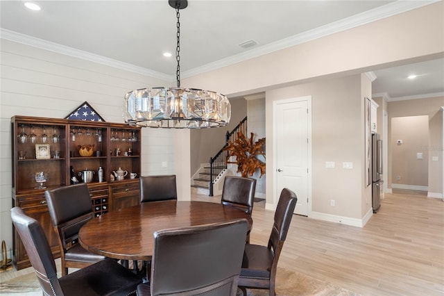 dining area with a notable chandelier, visible vents, stairs, crown molding, and light wood-style flooring