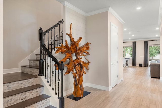 stairway featuring wood finished floors, baseboards, ornamental molding, and recessed lighting