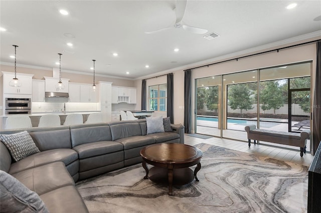 living area featuring recessed lighting, crown molding, visible vents, and light wood finished floors